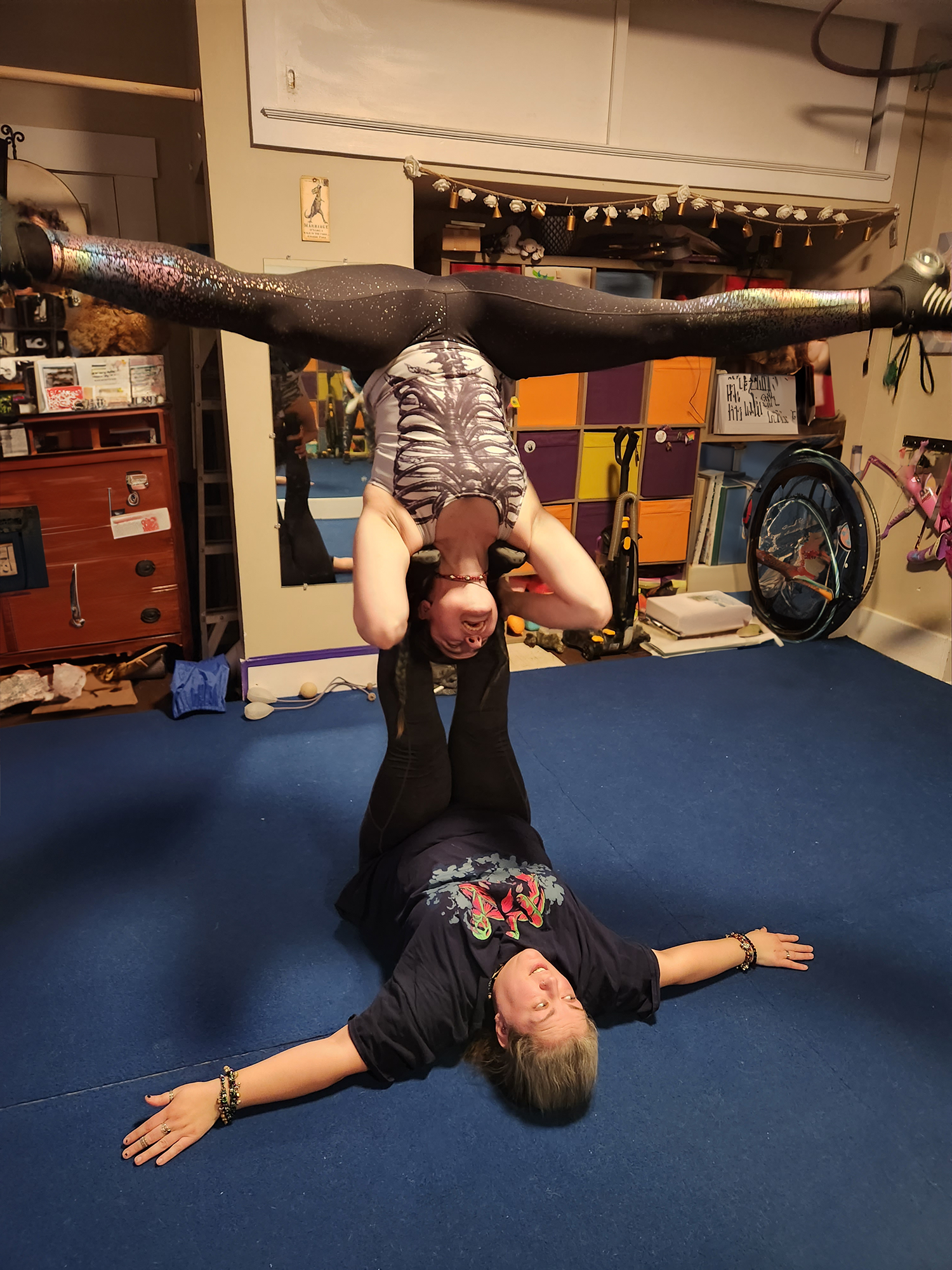 Ehlers Danlos Syndrome / Hypermobility portrayed by two women in acro-yoga, with Abi supporting Coryn.